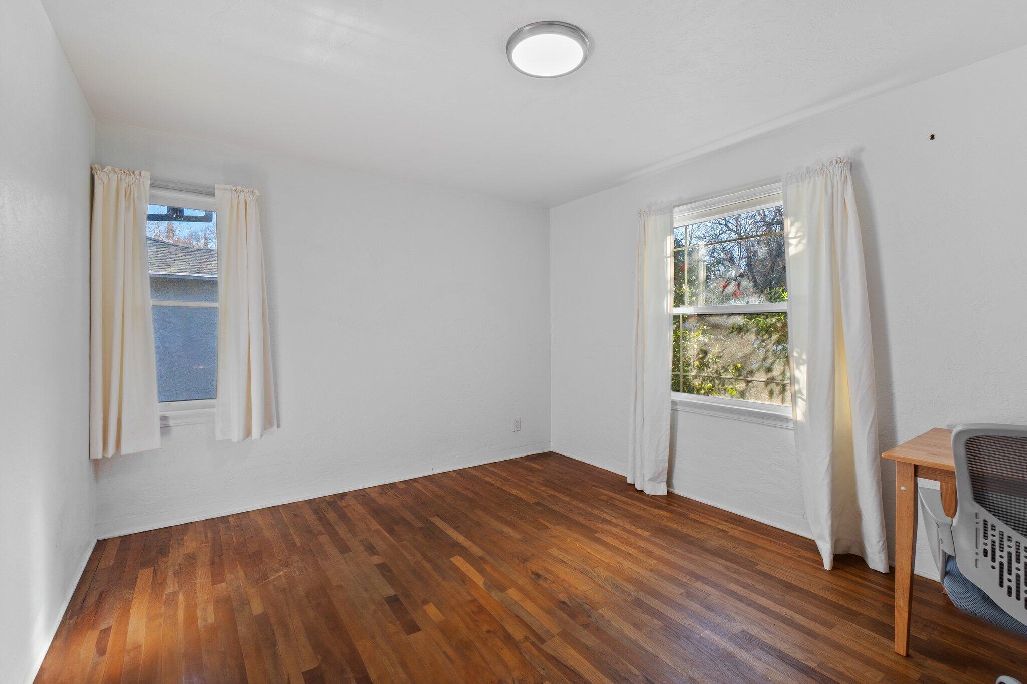 686 Coronado Street Redding, CA 96003 - Photo 31 of 39 an empty room with wooden floor and windows
