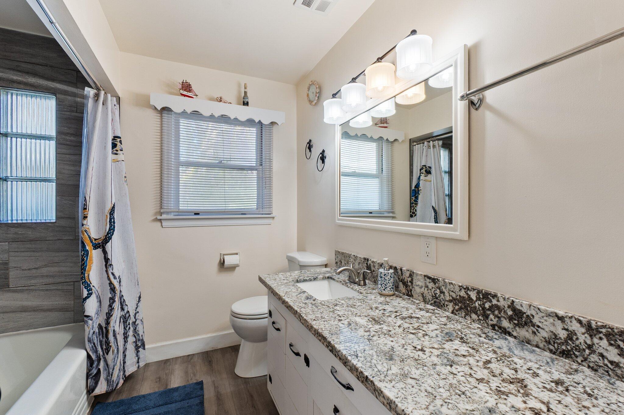 686 Coronado Street Redding, CA 96003 - Photo 8 of 39 a bathroom with a granite countertop sink toilet and mirror