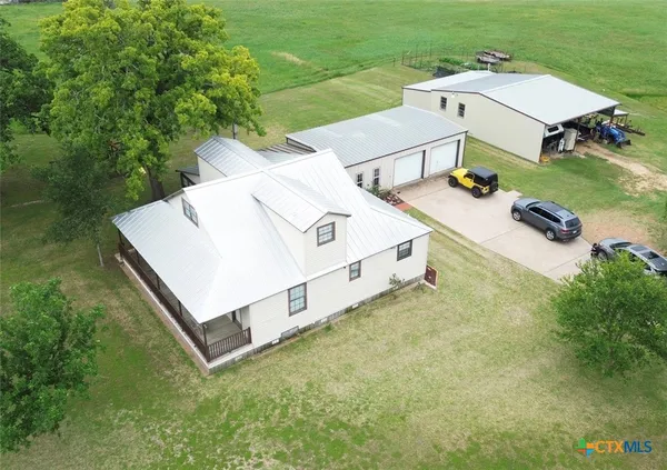 an aerial view of residential house with outdoor space and trees around