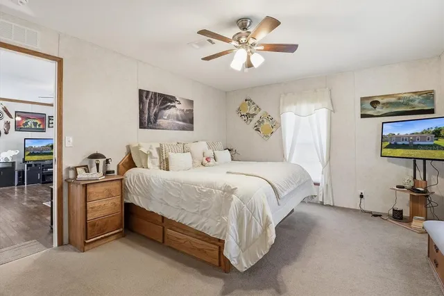 a spacious bedroom with a bed and a chandelier