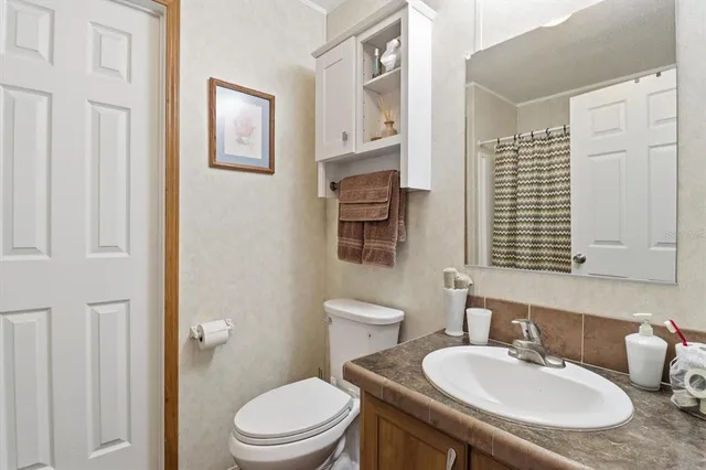 a bathroom with a sink toilet and mirror