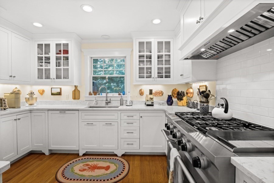 61 Causeway Road Tisbury, MA 02568 - Photo 15 of 42 a kitchen with a stove a sink and a wooden cabinets