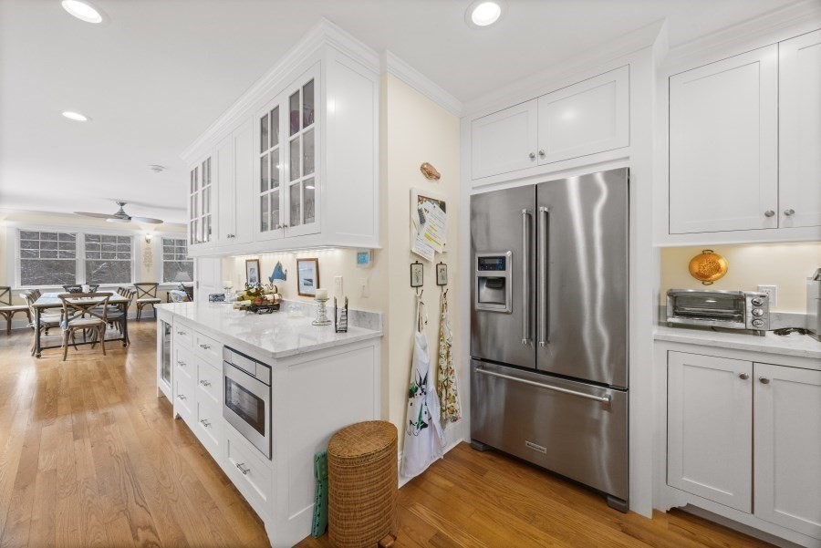 61 Causeway Road Tisbury, MA 02568 - Photo 16 of 42 a kitchen with a refrigerator a stove a sink dishwasher and white cabinets with wooden floor