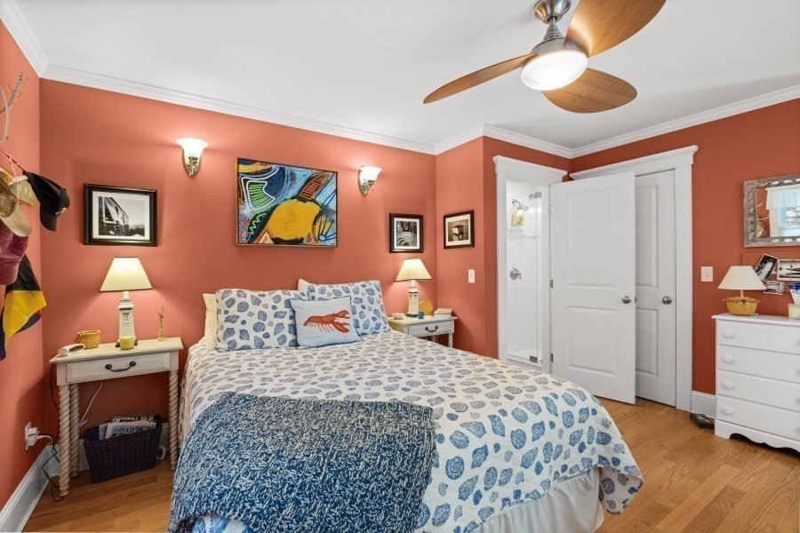 61 Causeway Road Tisbury, MA 02568 - Photo 19 of 42 a bedroom with a bed and a chandelier