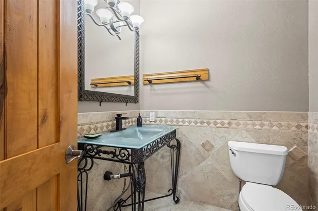 a bathroom with a granite countertop toilet sink and mirror