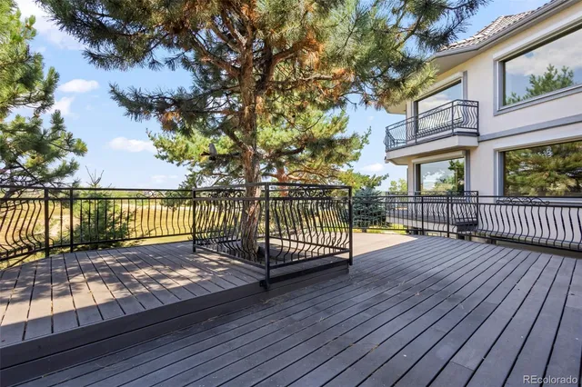 a view of a patio with wooden floor next to a yard