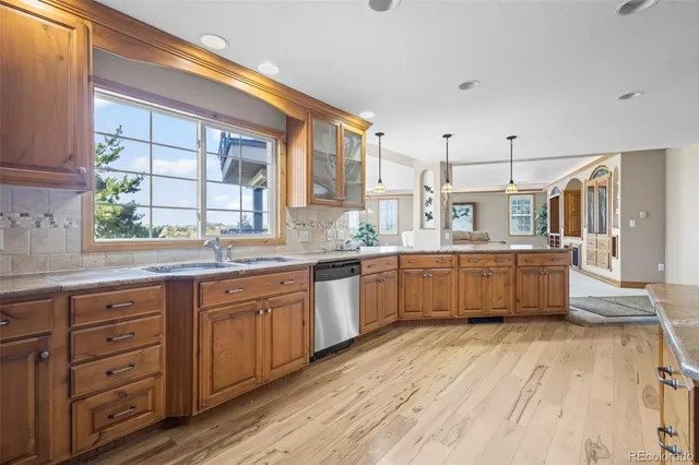 a large kitchen with a lot of counter space and wooden floor