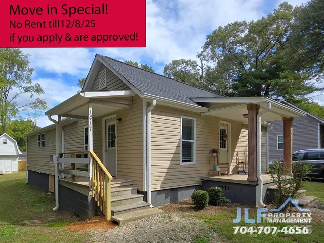 a view of a house with a small yard and wooden fence