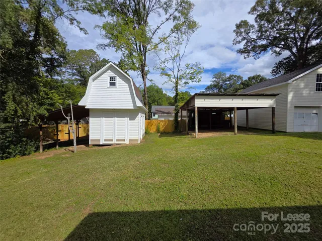 a front view of a house with a garden and tree