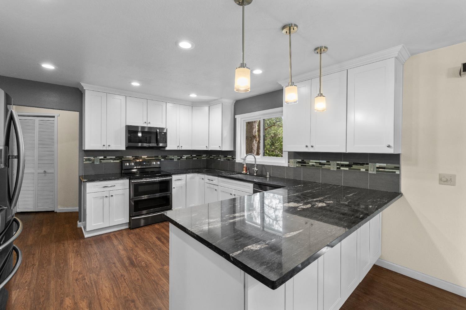 16173 Norlene Way Grass Valley, CA 95949 - Photo 3 of 25 a kitchen with stainless steel appliances granite countertop a sink a stove a refrigerator a center island and cabinets