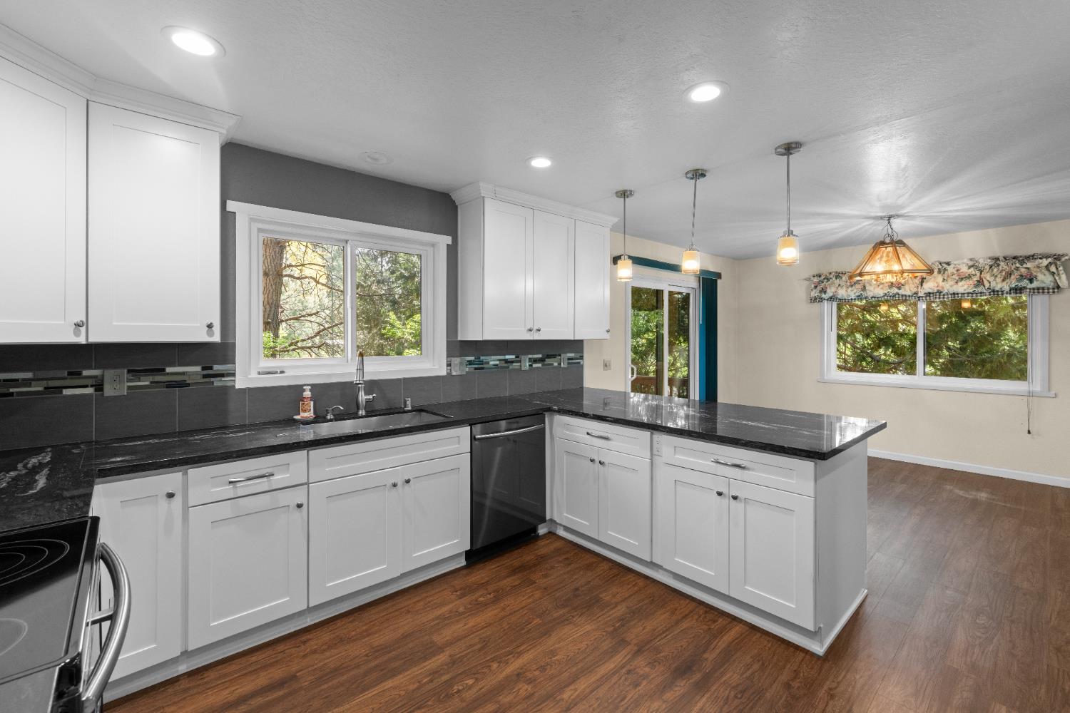 16173 Norlene Way Grass Valley, CA 95949 - Photo 5 of 25 a kitchen with granite countertop white cabinets and wooden floor