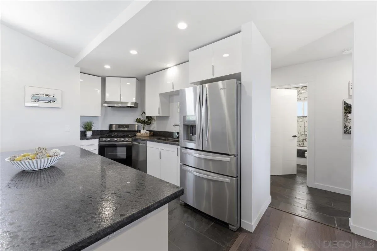 5447 Soledad Road La Jolla, CA 92037 - Photo 10 of 37 a kitchen with a refrigerator a sink and cabinets