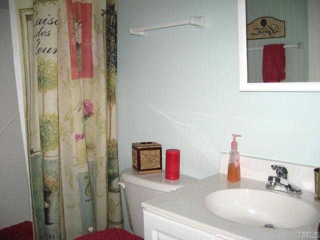 1300 Red Brick Road Garner, NC 27529 - Photo 9 of 12 a bathroom with a sink vanity and mirror