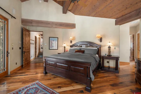 a bedroom with a bed and wooden floor