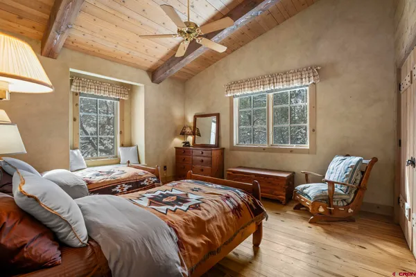 a bedroom with a bed a chair and next to a window