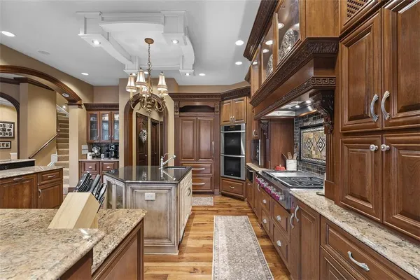 a view of a kitchen with kitchen island granite countertop a large counter top appliances and cabinets