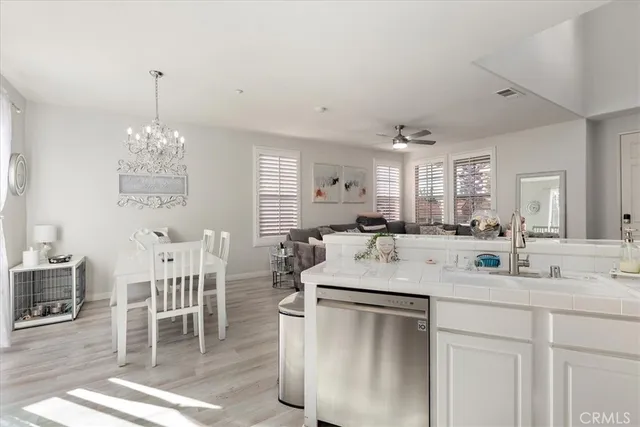 a kitchen with a dining table chairs sink and cabinets