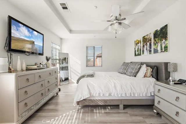 a bedroom with a large bed a flat tv screen and dresser