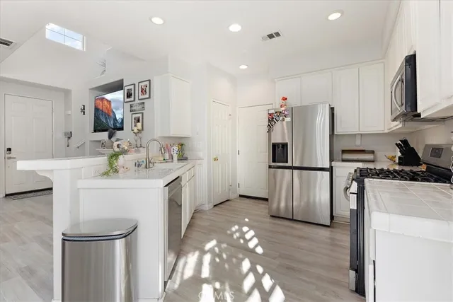 a kitchen with sink refrigerator and microwave
