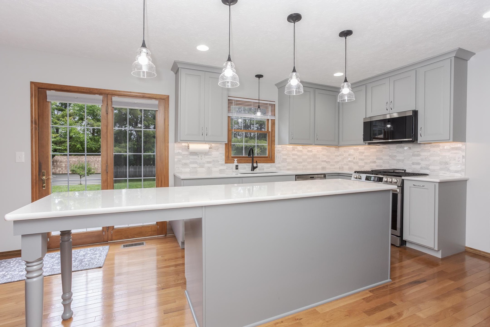 814 Landau Lane Normal, IL 61761 - Photo 21 of 58 a large kitchen with granite countertop a stove a sink a window and a wooden floor