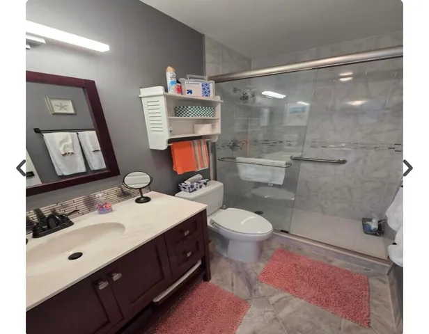 a bathroom with a sink mirror vanity and toilet