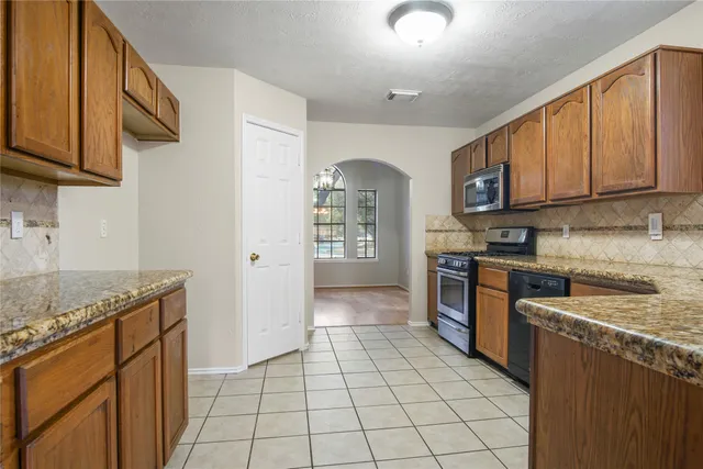 a kitchen with stainless steel appliances granite countertop a stove a sink and a microwave
