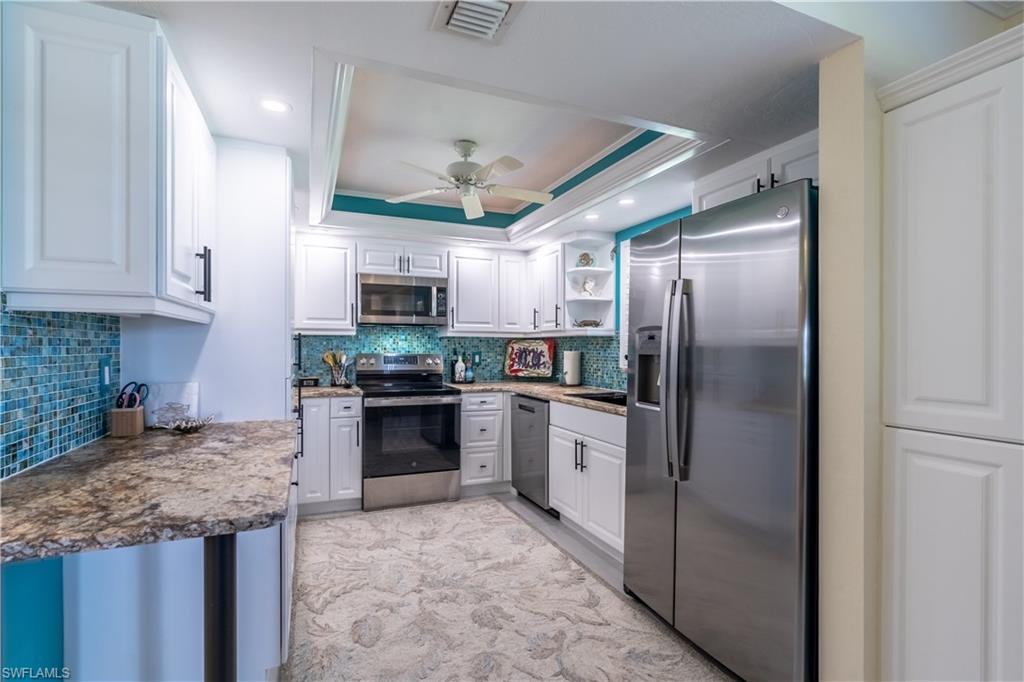 1071 8th Street South, Unit 103 Naples, FL 34102 - Photo 11 of 31 a kitchen with granite countertop stainless steel appliances and wooden cabinets