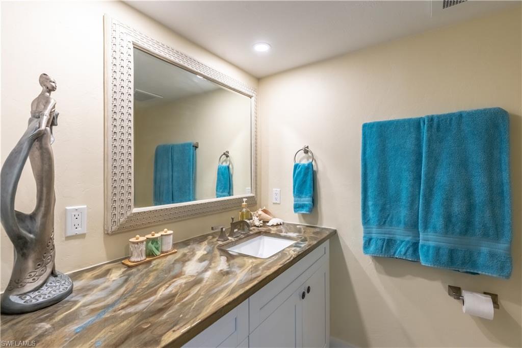1071 8th Street South, Unit 103 Naples, FL 34102 - Photo 16 of 31 a bathroom with a granite countertop sink and a mirror