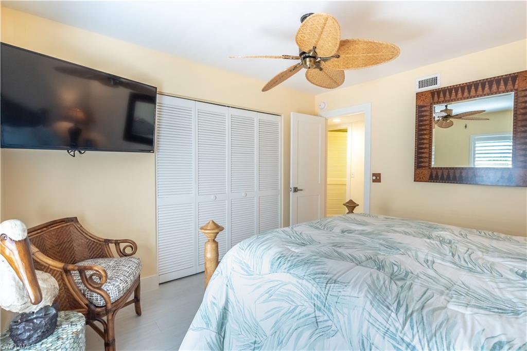 1071 8th Street South, Unit 103 Naples, FL 34102 - Photo 19 of 31 a bedroom with a bed and a chandelier