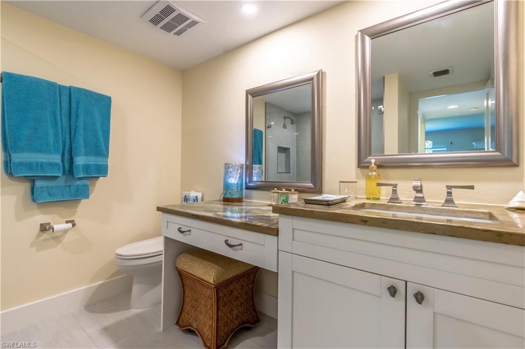 1071 8th Street South, Unit 103 Naples, FL 34102 - Photo 20 of 31 a bathroom with a granite countertop sink a toilet and a mirror