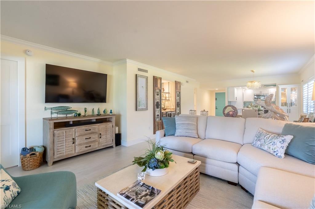 1071 8th Street South, Unit 103 Naples, FL 34102 - Photo 2 of 31 a living room with furniture and a flat screen tv