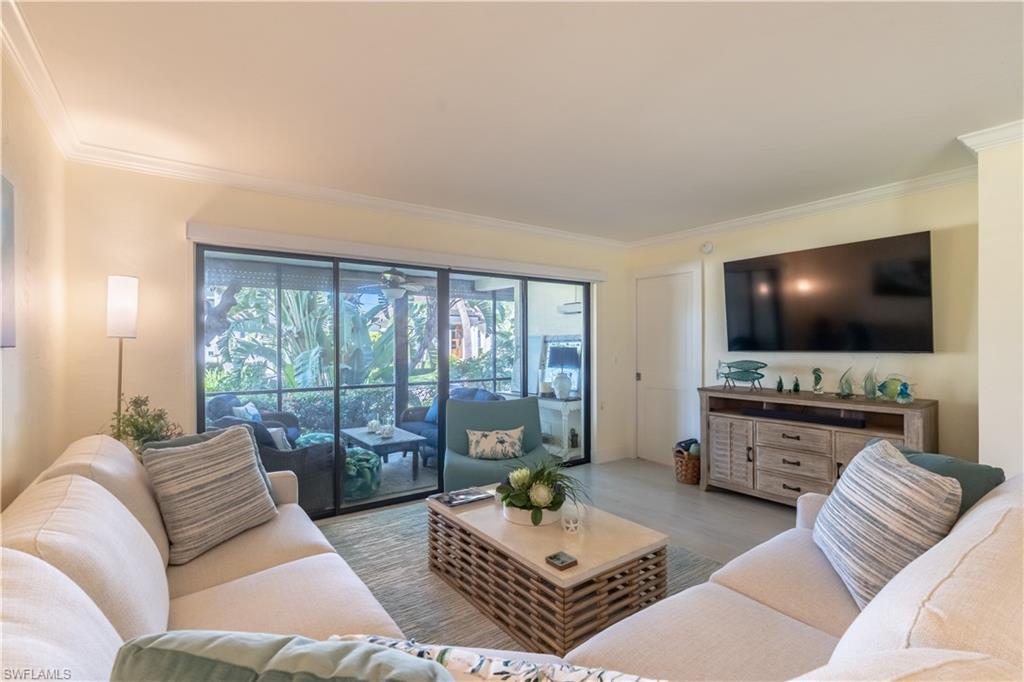 1071 8th Street South, Unit 103 Naples, FL 34102 - Photo 5 of 31 a living room with furniture and a flat screen tv