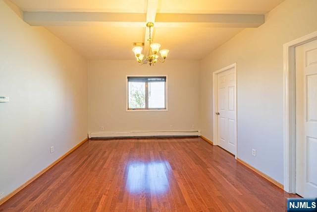 112 Prospect Street, Unit 2 Garfield, NJ 07026 - Photo 3 of 14 an empty room with wooden floor chandelier and window