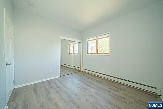112 Prospect Street, Unit 2 Garfield, NJ 07026 - Photo 4 of 14 an empty room with wooden floor and windows