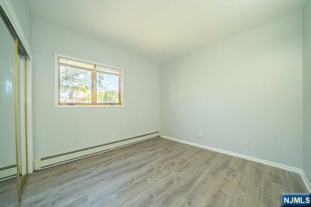112 Prospect Street, Unit 2 Garfield, NJ 07026 - Photo 5 of 14 an empty room with wooden floor and windows