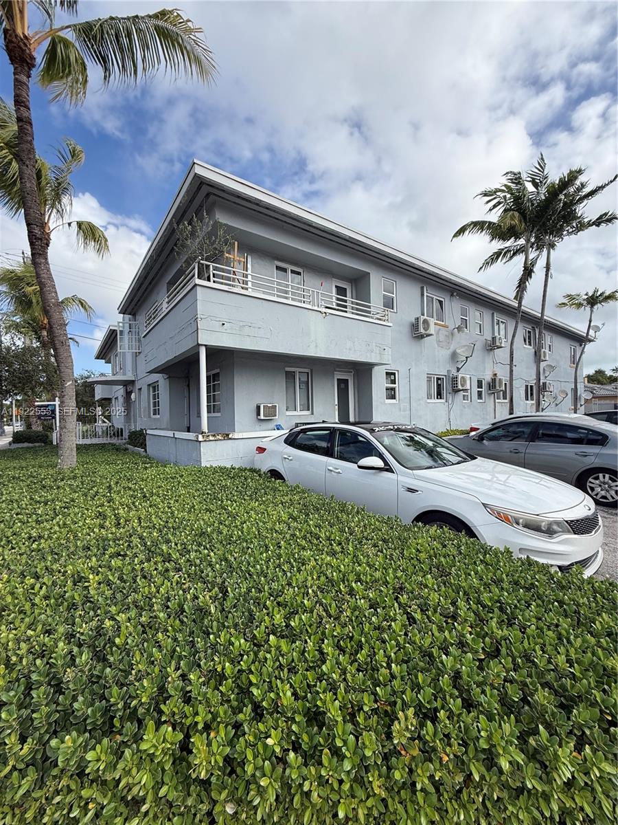 a front view of a house with a garden and plants
