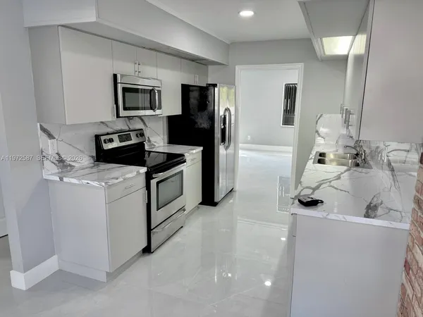 a kitchen with stainless steel appliances and white cabinets