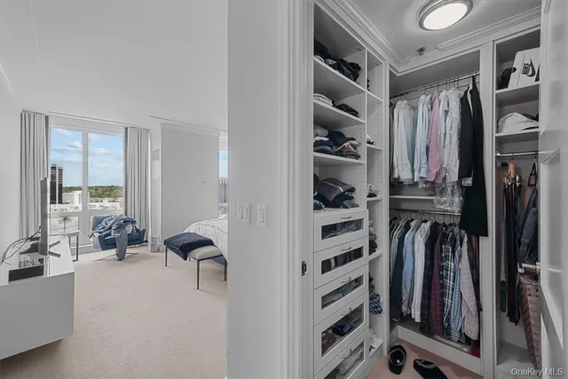 a view of walk in closet with clothes and shoes