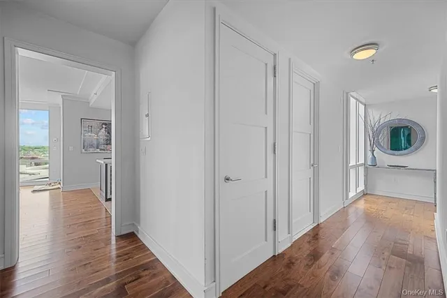 a view of a hallway with wooden floor and a living room