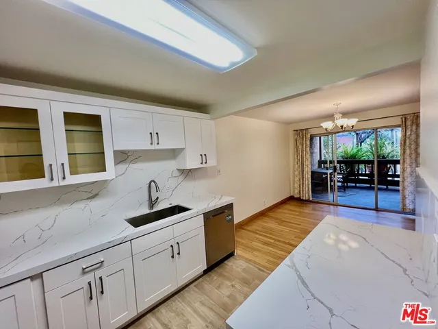 a kitchen with granite countertop a sink and cabinets
