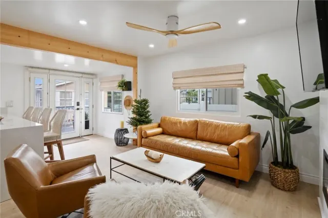 a kitchen with stainless steel appliances kitchen island granite countertop a refrigerator a stove a sink a dining table and chairs with wooden floor