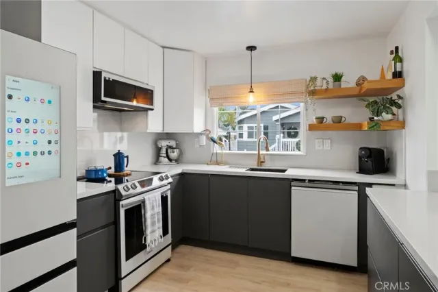 a kitchen with stainless steel appliances granite countertop a sink a stove and a microwave