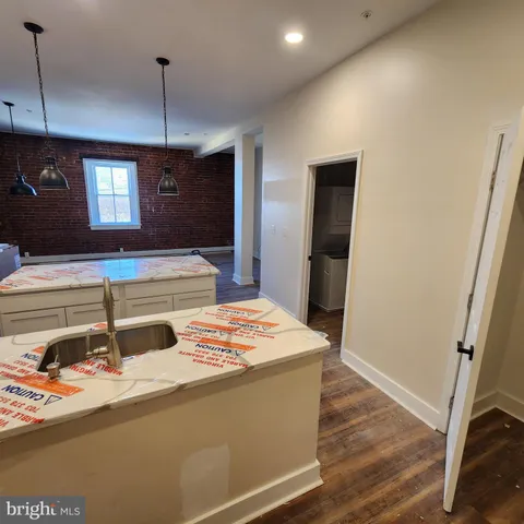 a room with wooden floor pool table and chandelier