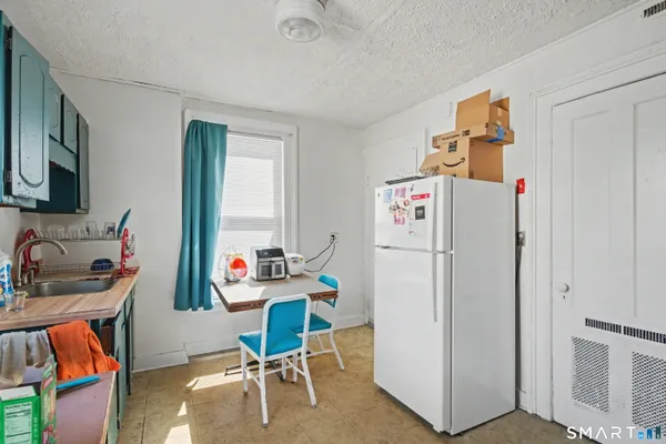 a room with furniture a refrigerator and a sink