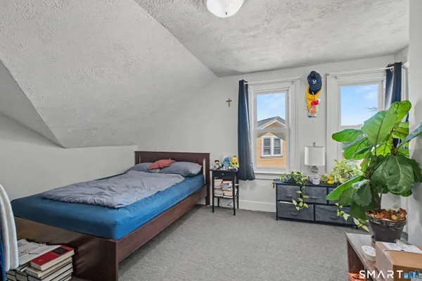 a spacious bedroom with a bed and a potted plant