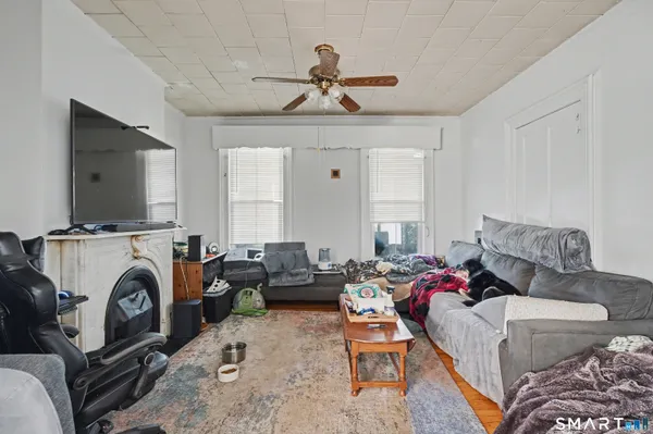 a living room with furniture a flat screen tv and a window