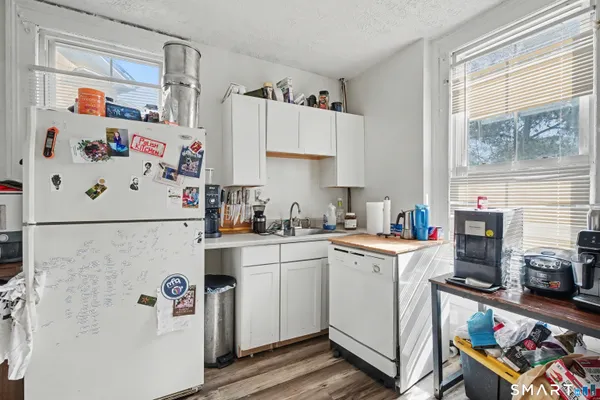 a kitchen with a refrigerator a stove a sink and wooden floor