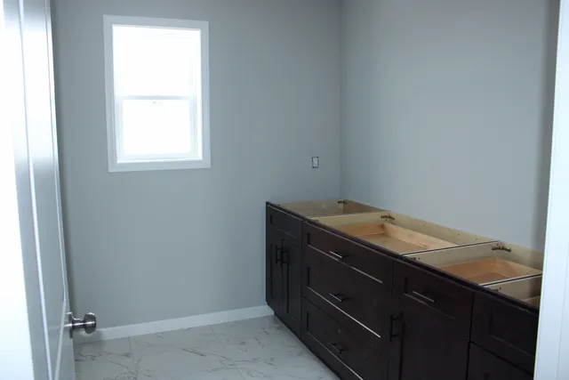 a bathroom with a granite countertop sink and window