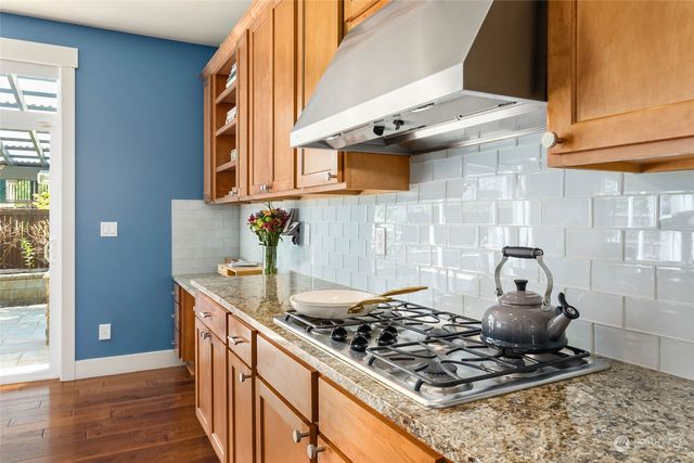 a kitchen with a stove and a wooden floor