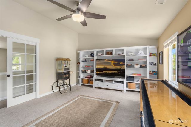 a living room with furniture a flat screen tv and a large window